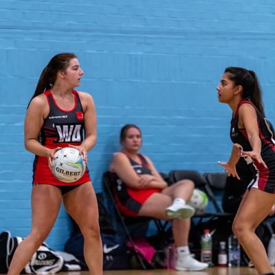 Wing attacker looks for a open teammate as she is covered by defence