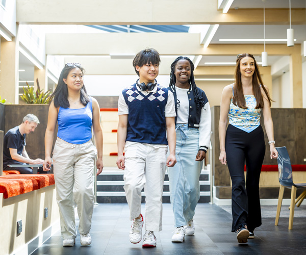 Students are smiling and walking through the modern open space in Stafford campus